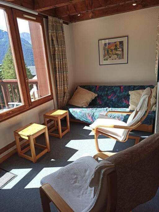 un salon avec un canapé, des chaises et des fenêtres dans l'établissement Paradiski ski au pied vallandry, à Landry