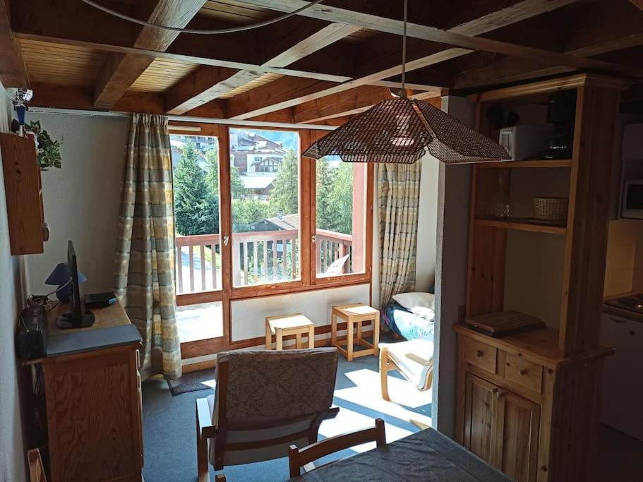 ein Wohnzimmer mit einem Stuhl und einem großen Fenster in der Unterkunft Paradiski ski au pied vallandry in Landry