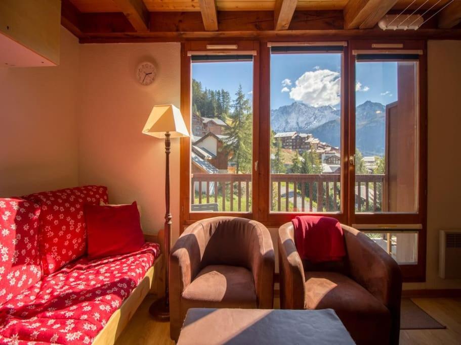 un salon avec un canapé, des chaises et une fenêtre dans l'établissement Paradiski ski au pied vallandry, à Landry
