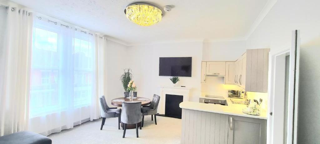 uma cozinha e sala de jantar com mesa e cadeiras em 3 bed flat 15 min walk from the sea with parking em Bournemouth