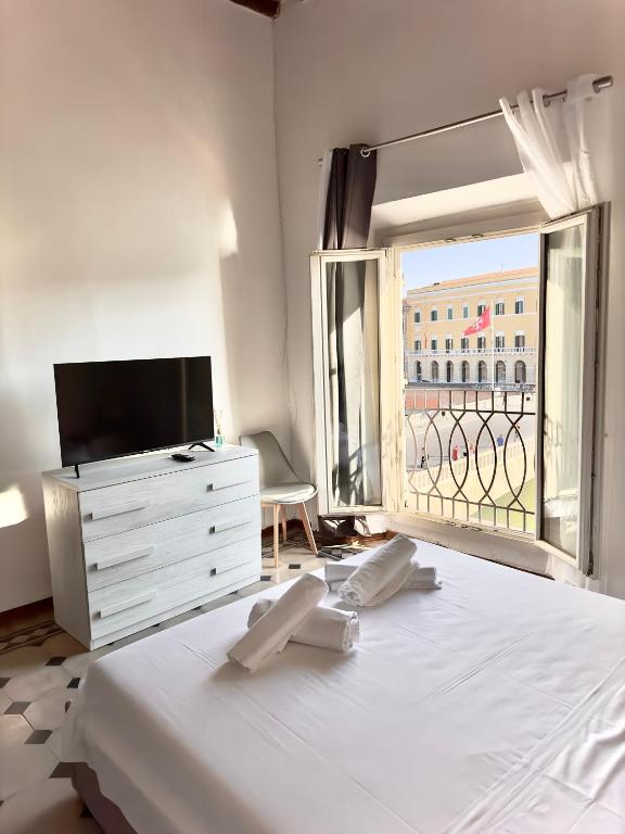 - une chambre avec un grand lit et une grande fenêtre dans l'établissement Lungarno Suite, à Pise