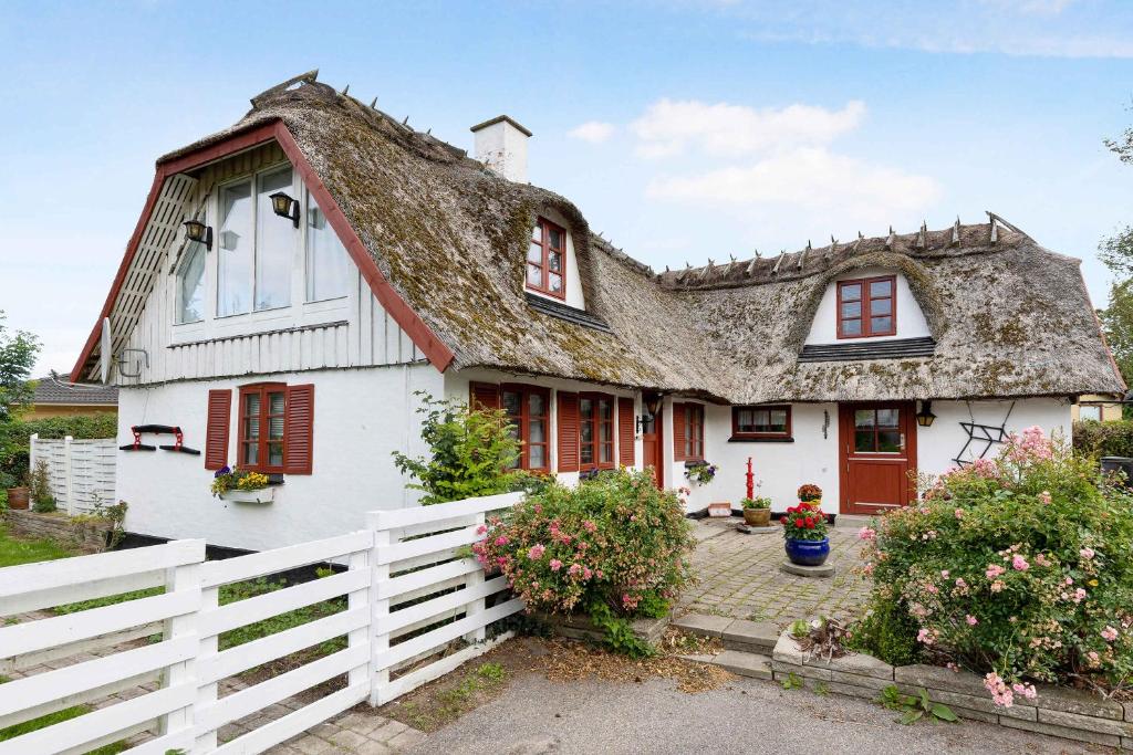 een wit huis met een rieten dak bij Frankerupvej 135, 4200 Slagelse in Slagelse