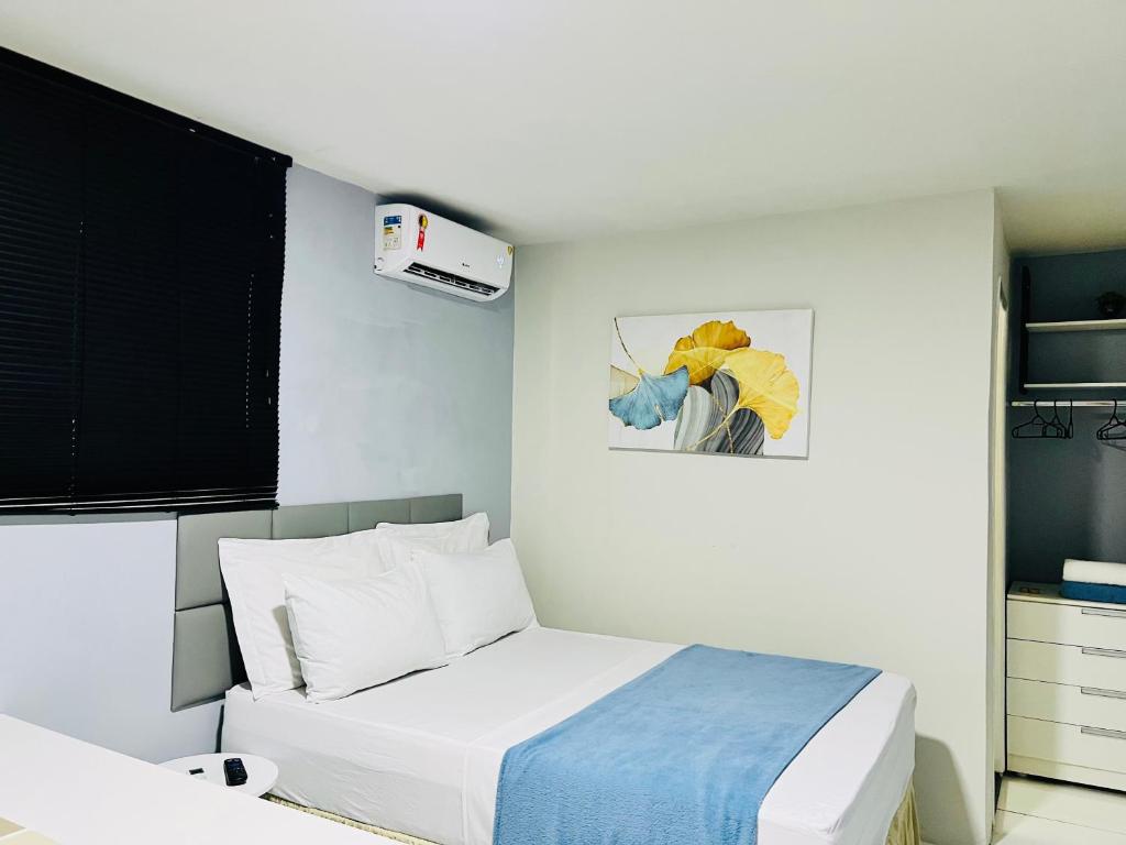 um quarto com uma cama e um quadro na parede em Edifício Creta em São Luís