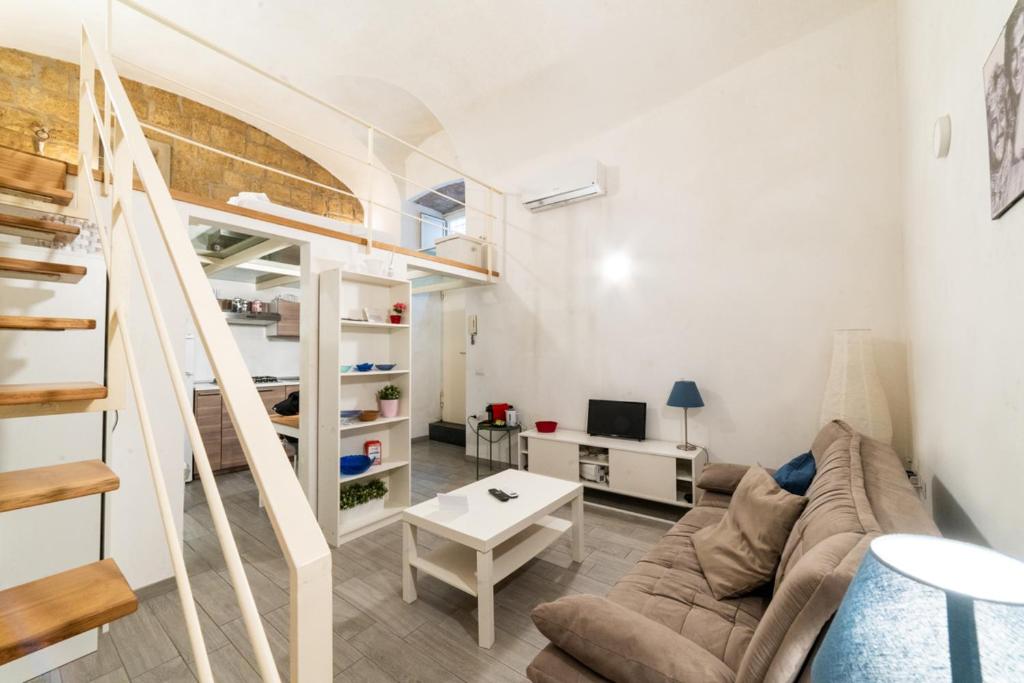 a living room with a couch and a staircase at Santa Maria degli Angeli Apartment in Naples