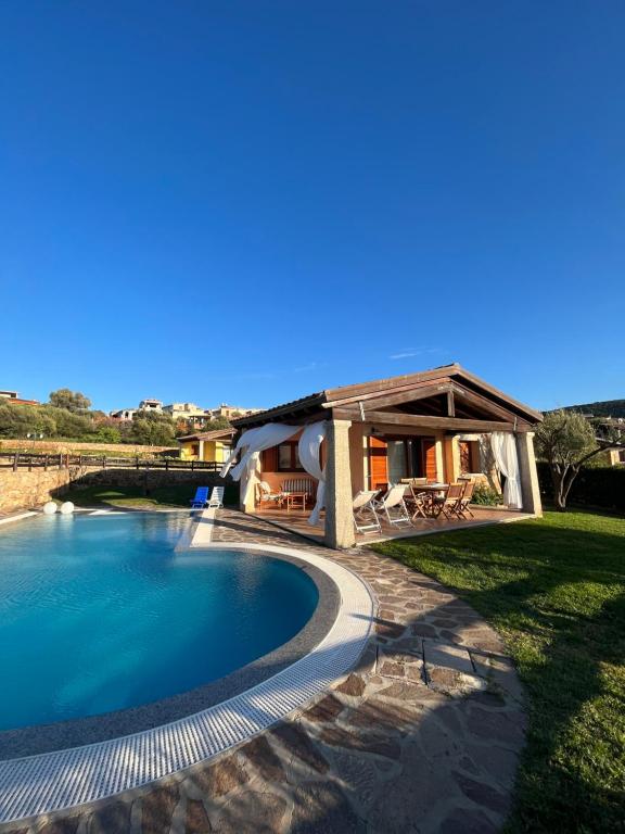 ein Haus mit einem Pool und einem Gebäude in der Unterkunft Villa Luca in Budoni
