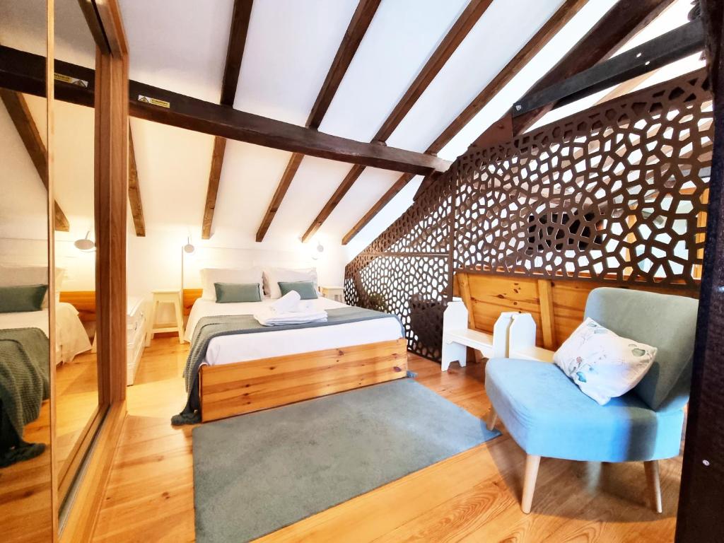 - une chambre avec deux lits et une chaise bleue dans l'établissement FeelCoimbra Mondego Views, à Coimbra
