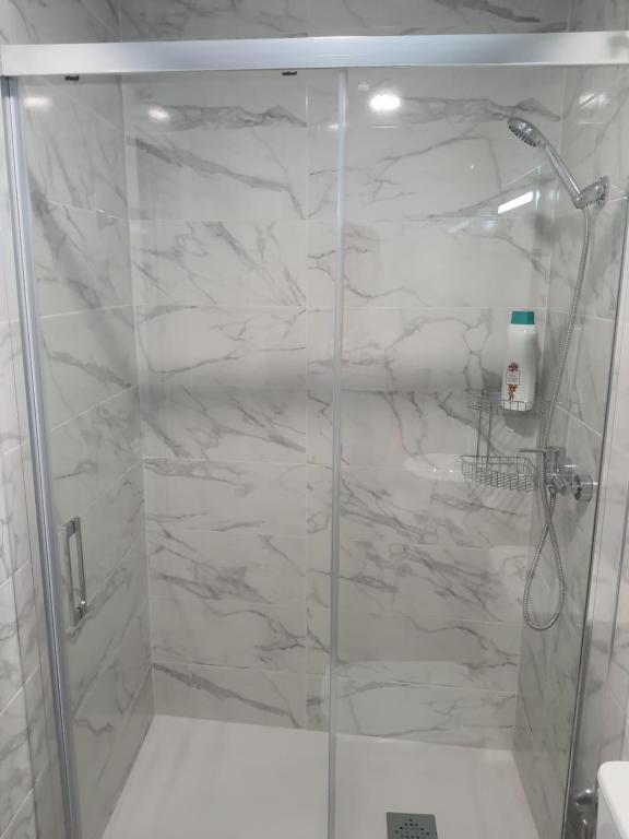 um chuveiro com uma porta de vidro na casa de banho em FANTÁSTICO PISO A 5 MINUTOS DE LA ESTACION DE BUS Y TREN a metros de la PLAYA em Málaga