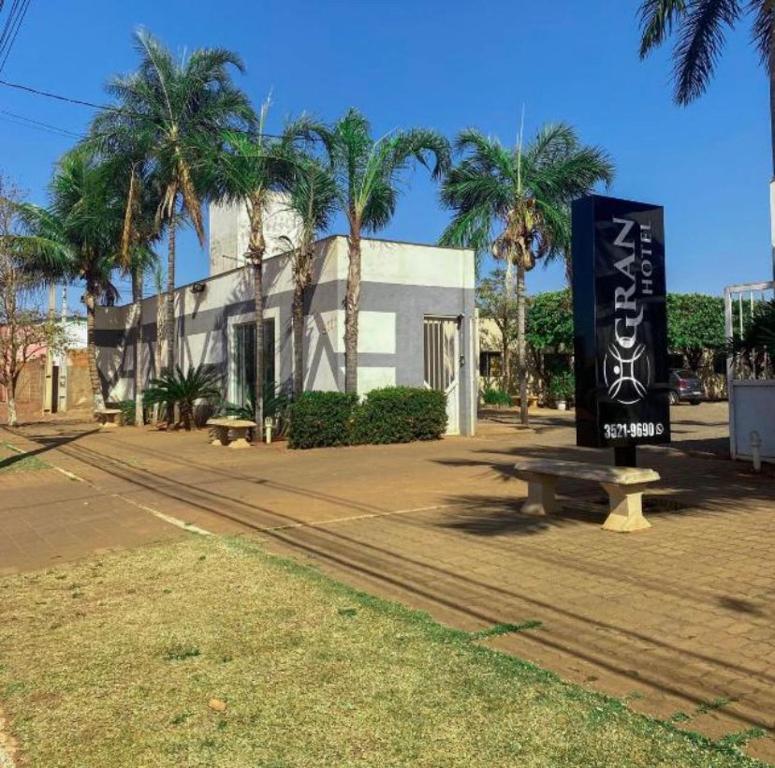 a park with a bench and a sign in front of a building at GRAN HOTEL in Três Lagoas