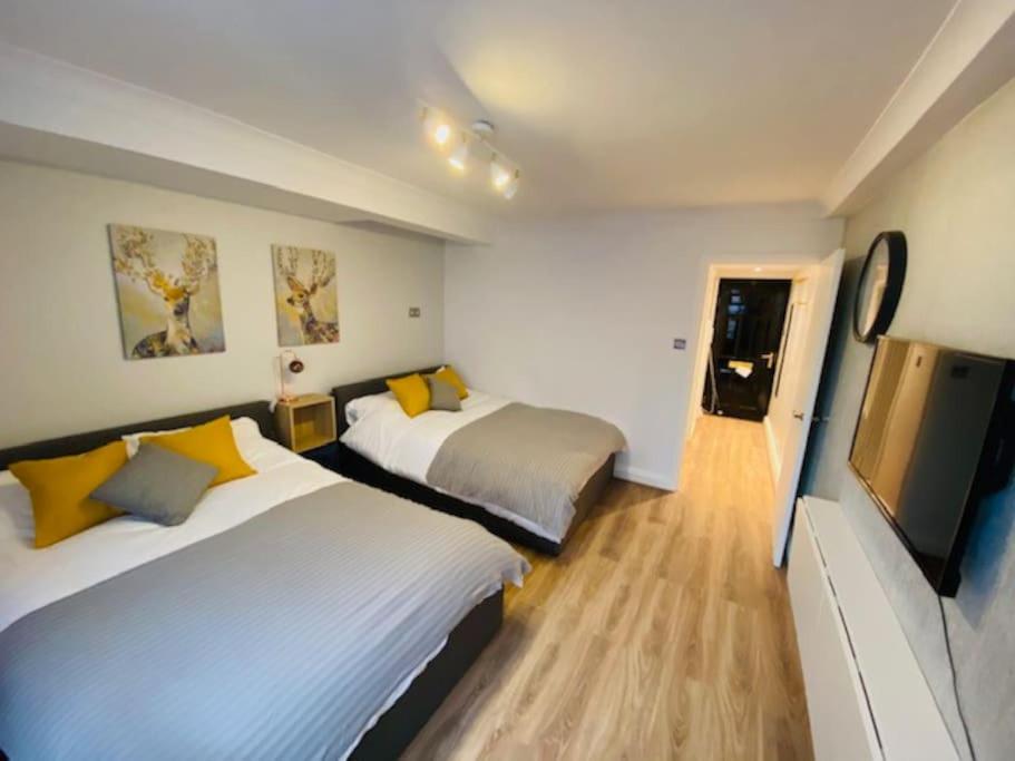 um quarto de hotel com duas camas e uma televisão de ecrã plano em Lovely HotelStyle Apartment - Central London em Londres