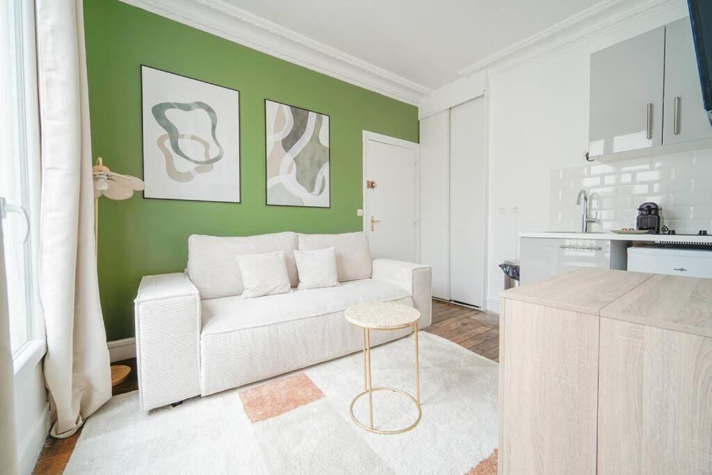 un salon avec un canapé blanc et une table dans l'établissement Apartment proche Vaugirard - Sauge - II, à Paris