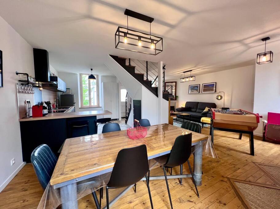 a dining room and living room with a table and chairs at Charmante & Paisible Villa Platon - Jacuzzi & Jardin - Brive in Brive-la-Gaillarde