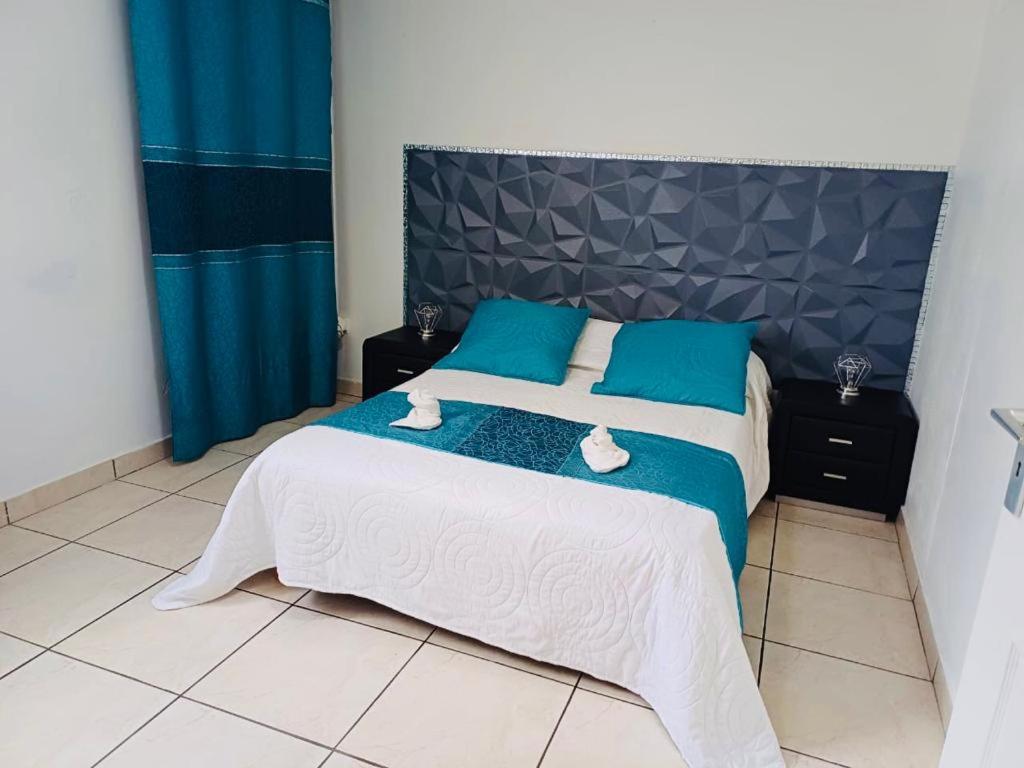 Postel nebo postele na pokoji v ubytování COQUET F2 CLIMATISE AVEC PISCINE AU LAMENTIN