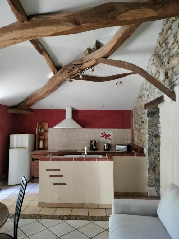 una cucina con pareti rosse e travi in legno di Maison Pucet a Pey