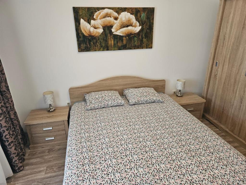 a bedroom with a bed and a painting on the wall at Apartament Holiday in Mamaia Nord