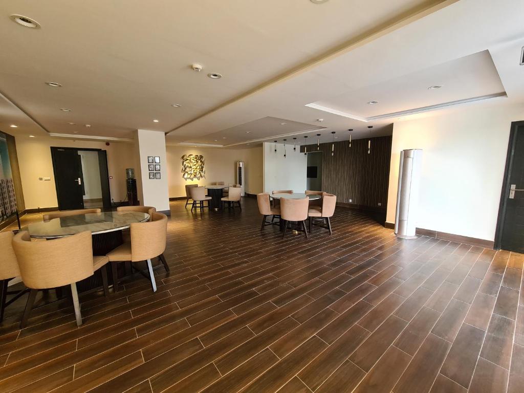 a large room with a table and chairs at 1 Bed Modern Apartment, Pool, Gym, Cinema in Lahore
