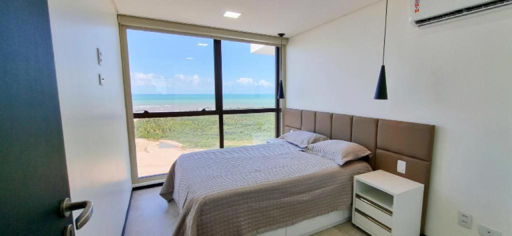 - une chambre avec un lit et une vue sur l'océan dans l'établissement Flat a beira mar, à Récife