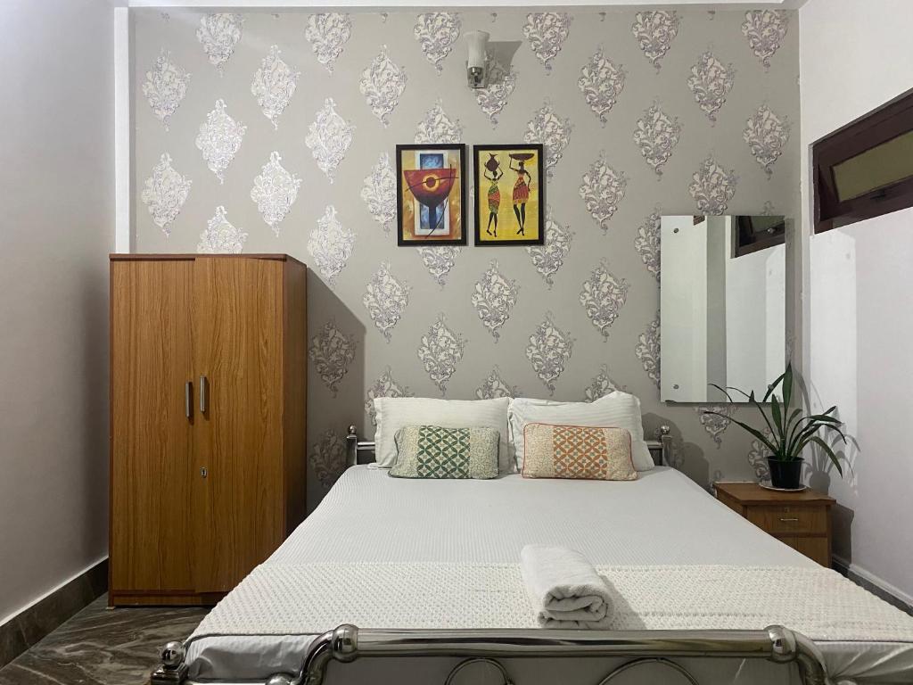 sypialnia z łóżkiem i drewnianą szafką w obiekcie Lasaya apartment w mieście Siliguri