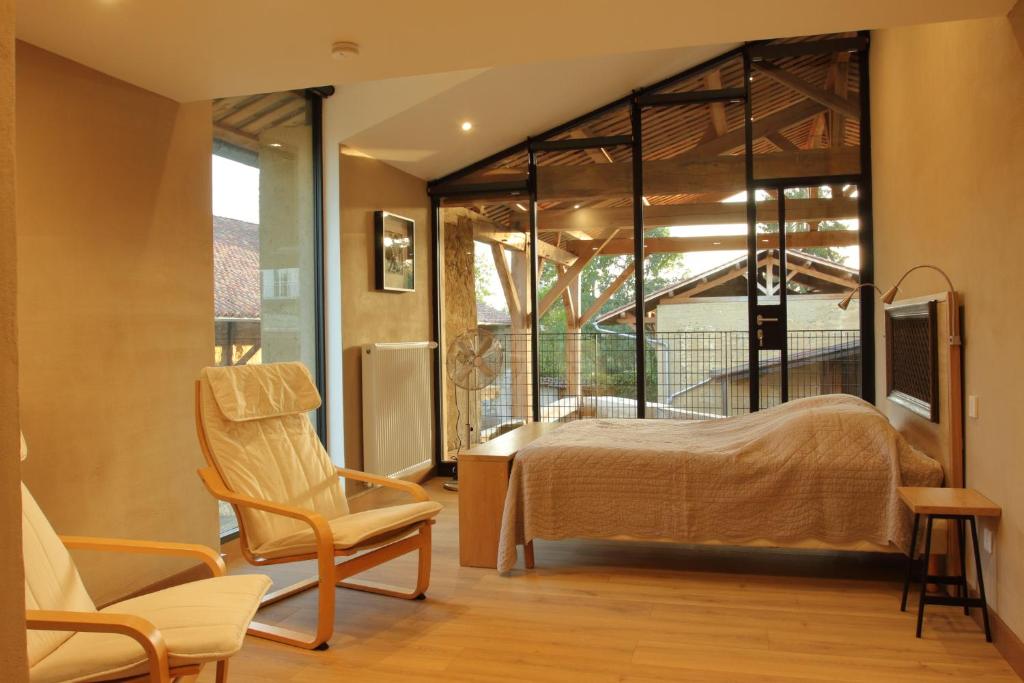 a bedroom with a bed and a desk and a chair at La ferme de Berlioz in La Côte-Saint-André