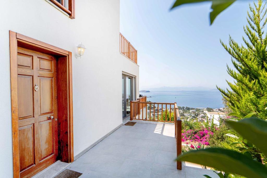 a door to a balcony with a view of the ocean at Sea View Flat with Terrace 3 min to Beach in Gumusluk