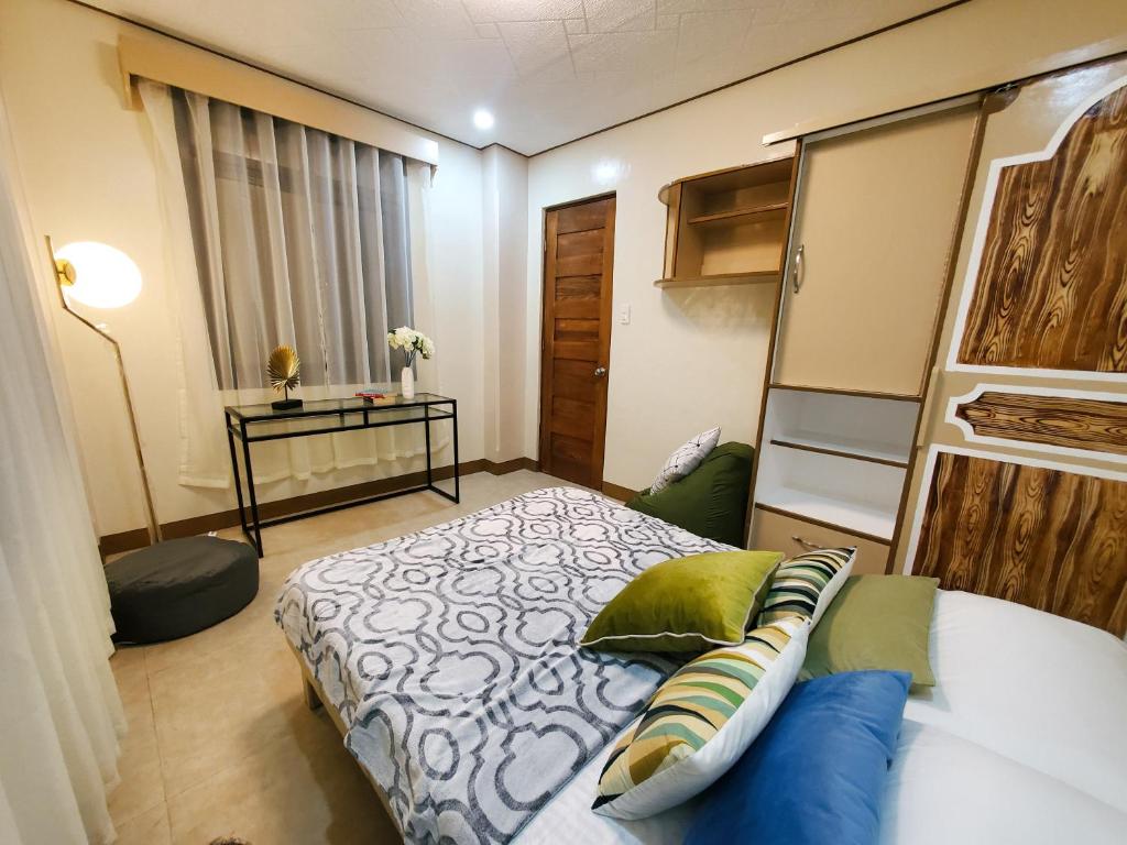 a small bedroom with a bed and a table at Mirador Modern House - Walking distance to Lourdes Grotto in Baguio