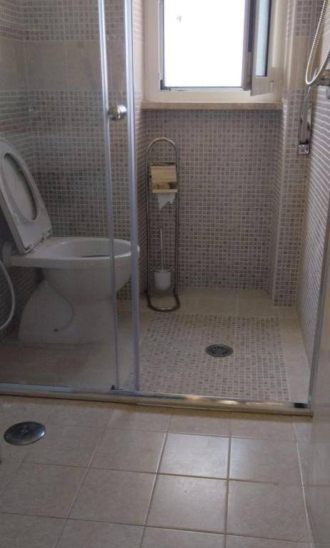 a bathroom with a shower with a toilet and a window at Casa Lea - Sperlonga in Sperlonga