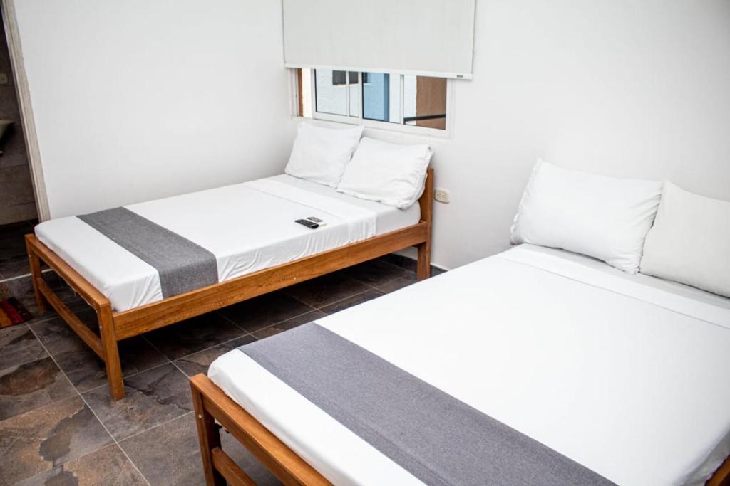 sypialnia z 2 łóżkami i oknem w obiekcie Aw Hotel Palm Bay Bello Horizonte w mieście Santa Marta