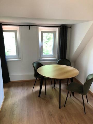 comedor con mesa, sillas y 2 ventanas en 2 Zimmer Wohnung in Giessen-Mitte en Gießen