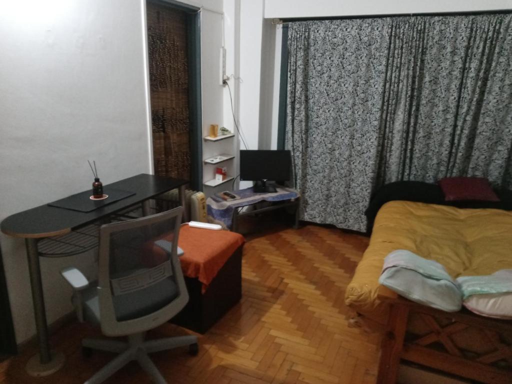 Habitación con escritorio, cama, escritorio y TV. en Destino Buenos Aires en Buenos Aires