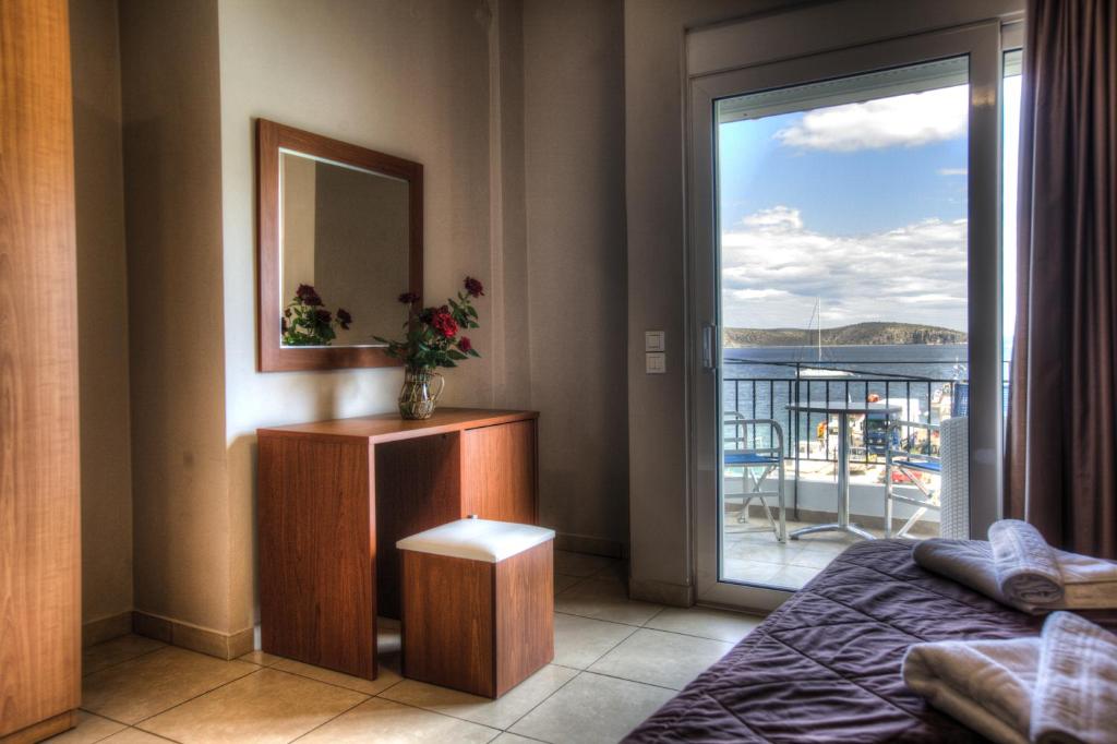 a bedroom with a bed and a door to a balcony at Hotel Apanema in Vivari