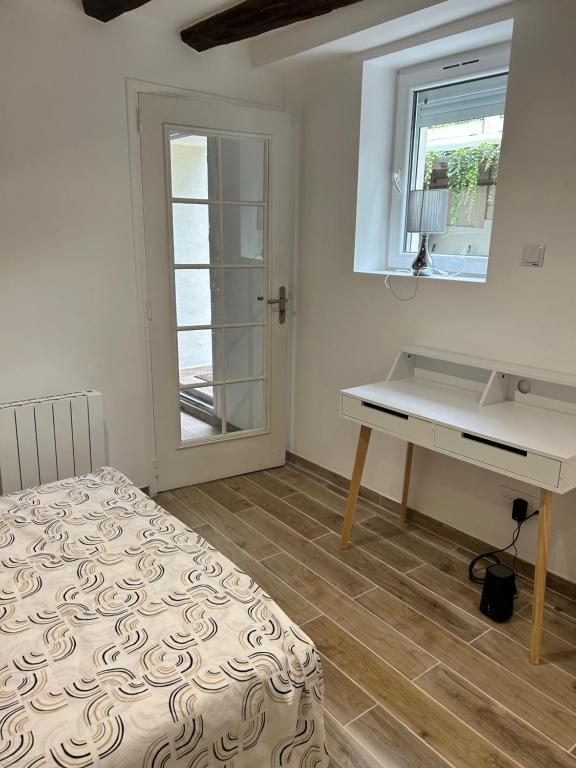 a bedroom with a bed and a desk and a window at Belle F2 centre ville Massy avec jardin in Massy