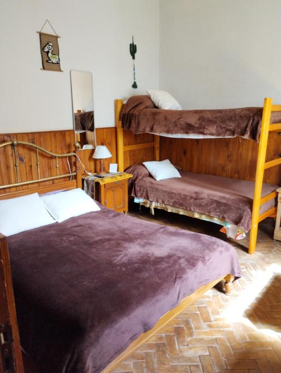 1 dormitorio con 2 literas y mantas moradas en Lo de Su en Salta