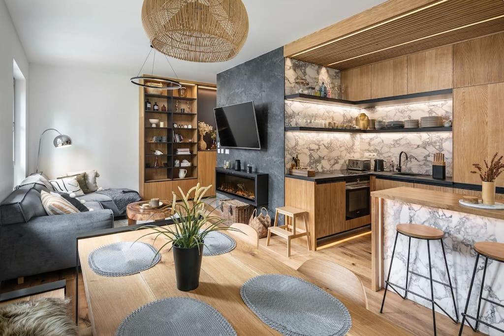 cocina y sala de estar con sofá y mesa en Luxury 2 Bedroom Mountain Escape, en Harrachov