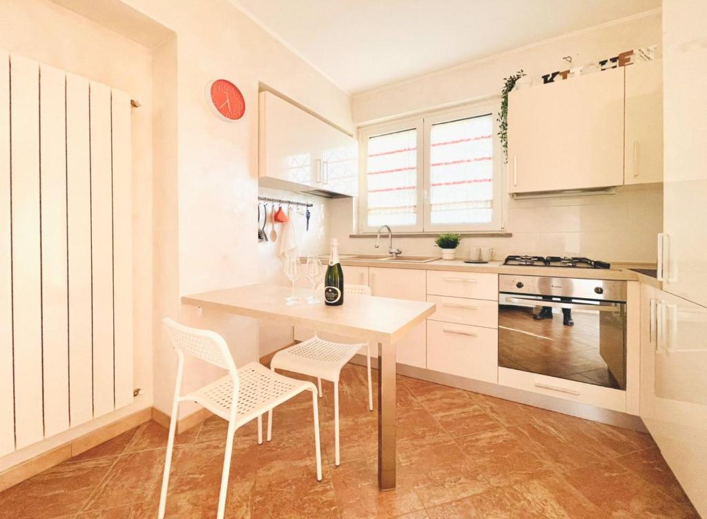 Manziana的住宿－[La Casina Del Colle] Confort,Centrale,P. Gratuito.，厨房配有白色橱柜和桌椅