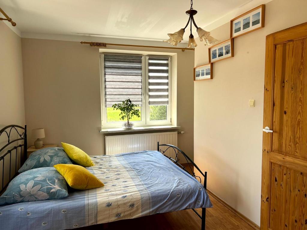 sypialnia z łóżkiem i oknem w obiekcie Pokoje PRZY SZELMENCIE w mieście Jeleniewo