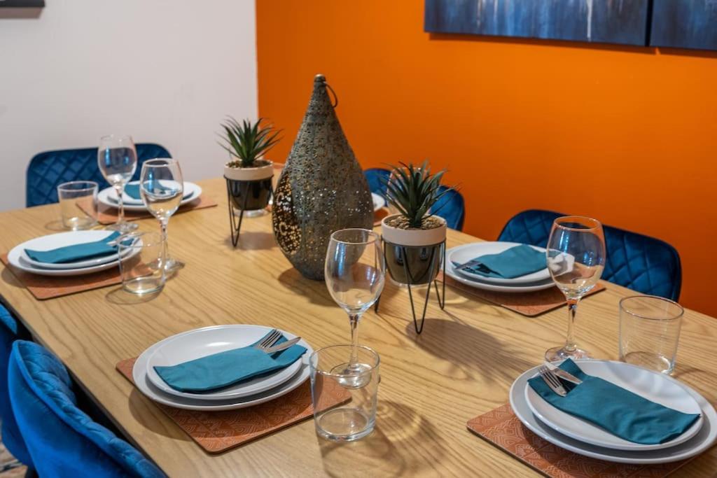 una mesa de madera con platos y copas de vino. en Harvest House - TV in every bedroom! en Swansea