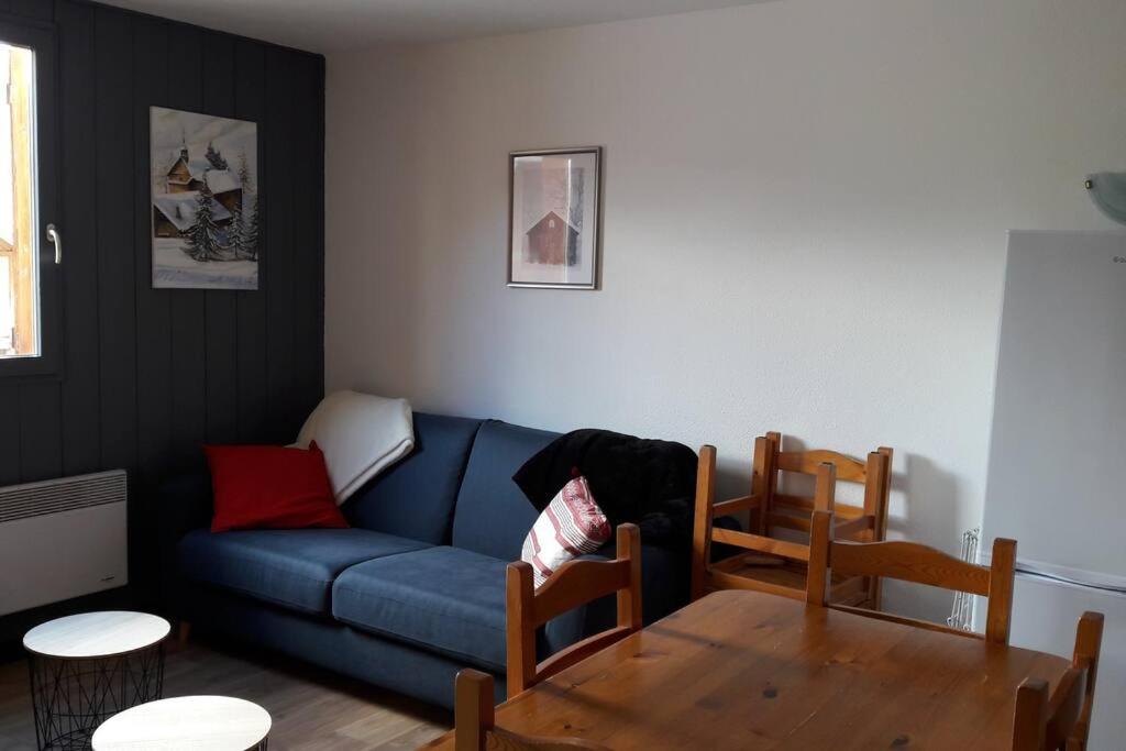 a living room with a blue couch and a table at APPARTEMENT PIEDS DE PISTE - 4-6 PERSONNES in La Chal