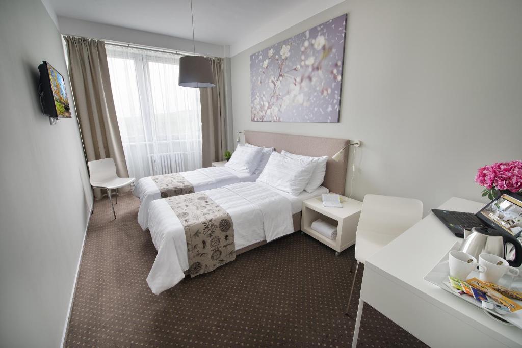 a hotel room with a bed and a desk at Hotel Energie in Prague