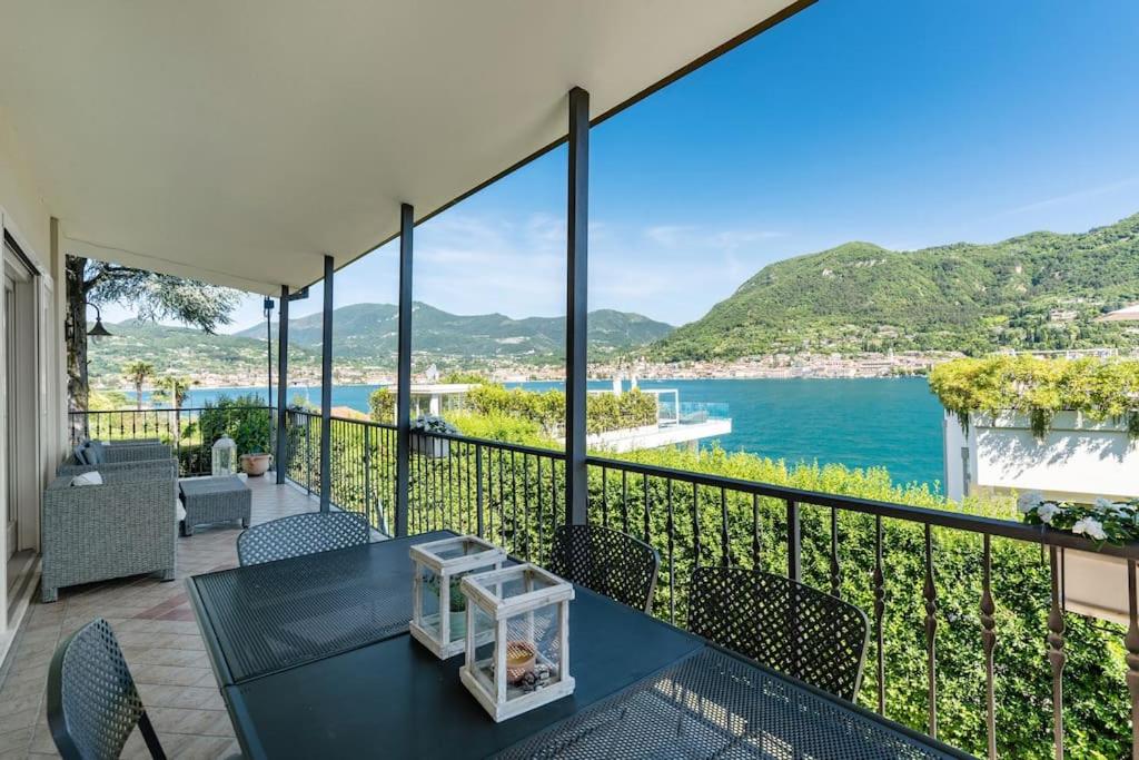 サン・フェリーチェ・デル・ベナーコにあるLake View Garda Villa Salò Gulfの水辺の景色を望むバルコニー(テーブル、椅子付)