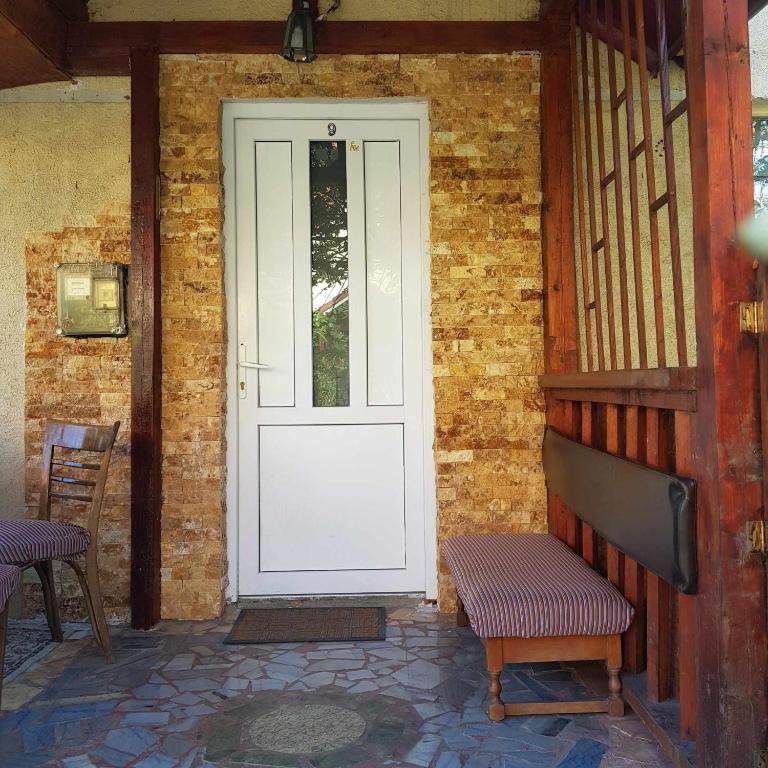 una puerta blanca en una casa de ladrillo con un banco en Casa Eni en Cluj-Napoca