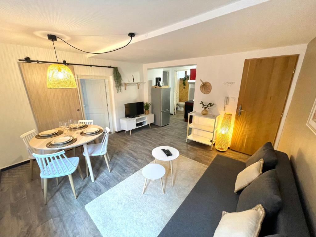 ein Wohnzimmer mit einem Sofa und einem Tisch in der Unterkunft Au nid des remparts à Eguisheim in Eguisheim