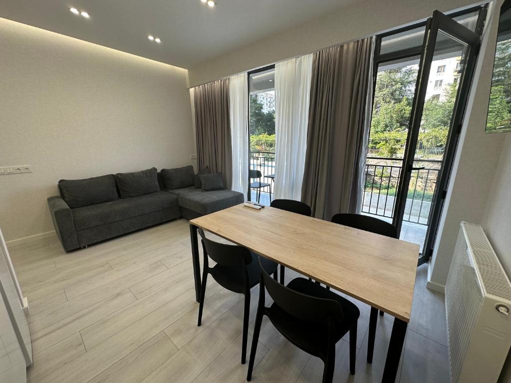 salon ze stołem, krzesłami i kanapą w obiekcie GSS - 5 Apartment w mieście Tbilisi City