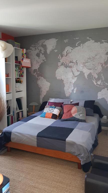 una camera con un grande letto con una mappa sul muro di Chez Laurence & RV a Vauréal