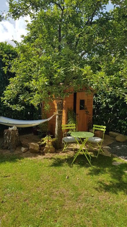 a hammock and a tree in front of a shed at Chez Laurence &amp; RV in Vauréal