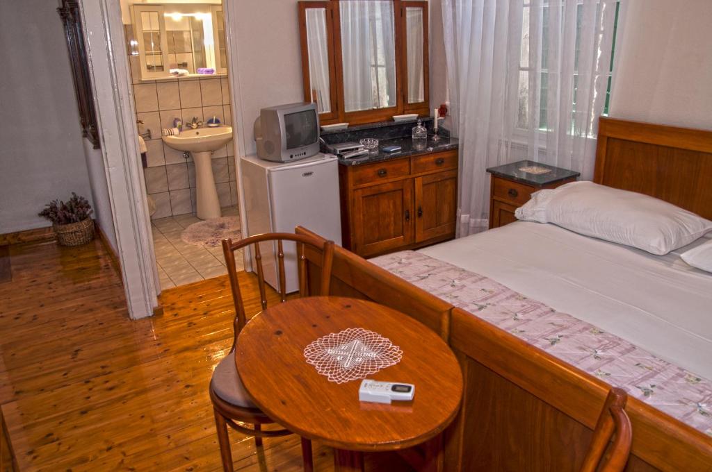 a bedroom with a table and a bed and a bathroom at Marina Rooms in Komiža