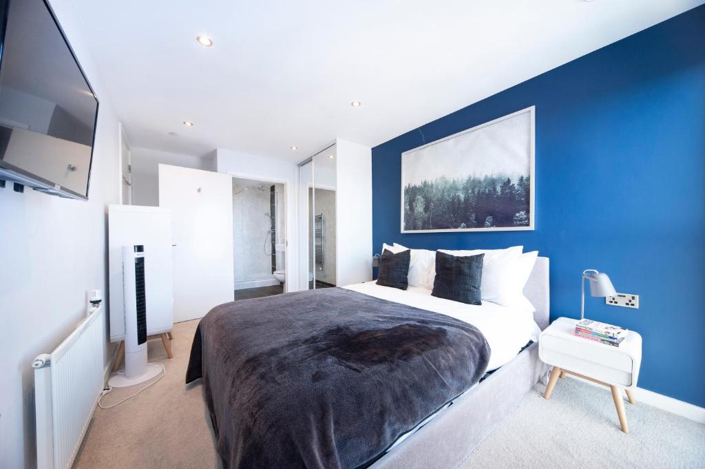 sypialnia z dużym łóżkiem z niebieską ścianą w obiekcie Top Floor Apt - 2 Bed/2 Bath + Private Balcony w Londynie