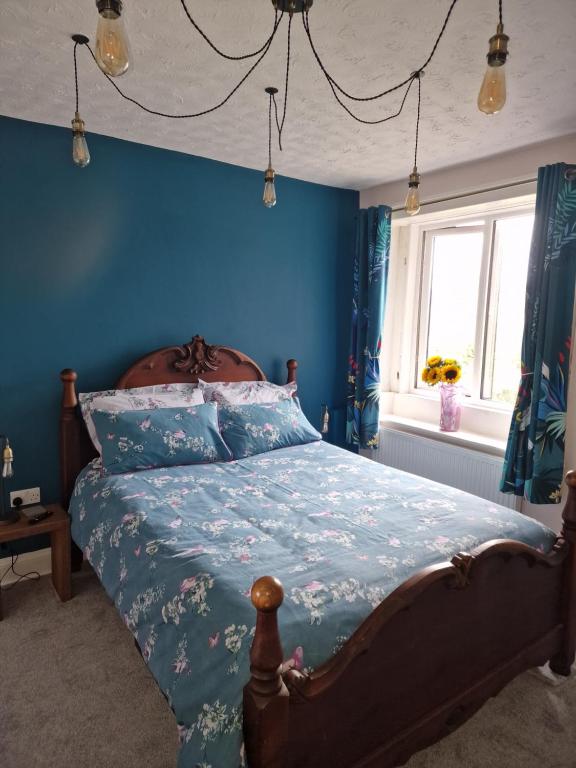 a bedroom with a bed with a blue wall at Fylde Court in Morecambe