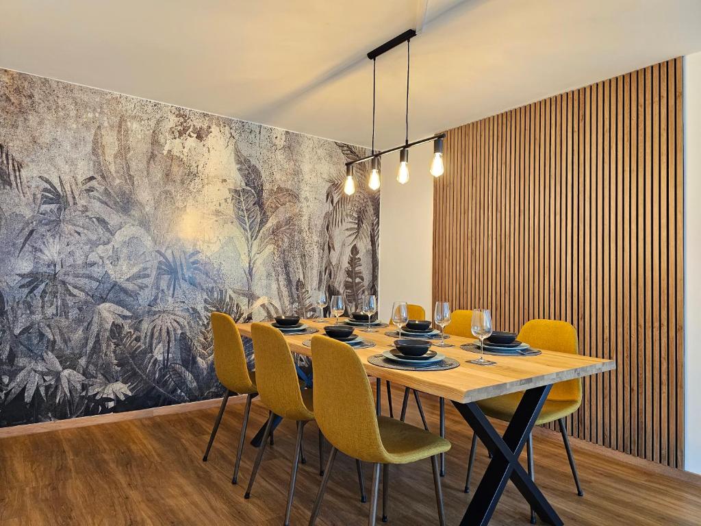 a dining room with a table and yellow chairs at Ara - Loft, Big Terrace, BBQ, Tischkicker, PS4, Stream in Marburg an der Lahn