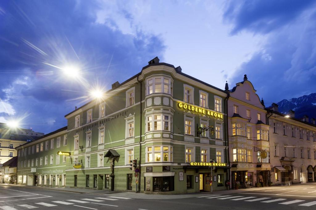 ein großes Gebäude in der Nacht auf einer Stadtstraße in der Unterkunft Hotel Goldene Krone Innsbruck in Innsbruck