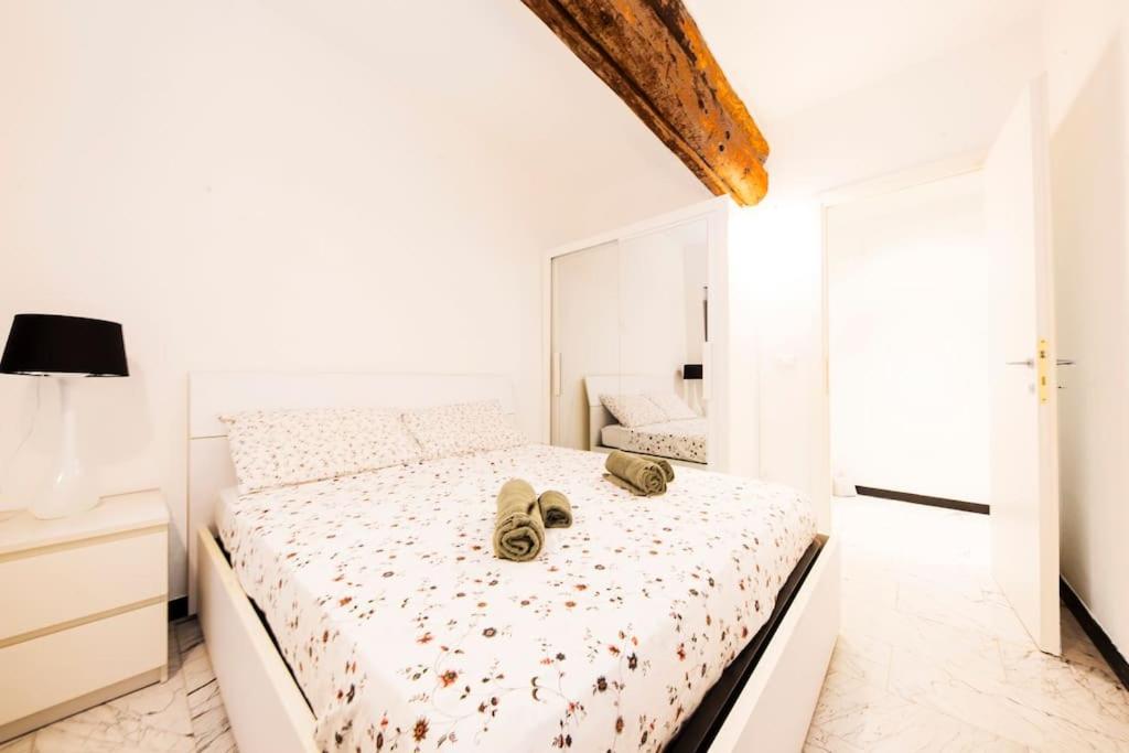biała sypialnia z łóżkiem z butami w obiekcie Appartamento La Città Vecchia w Genui