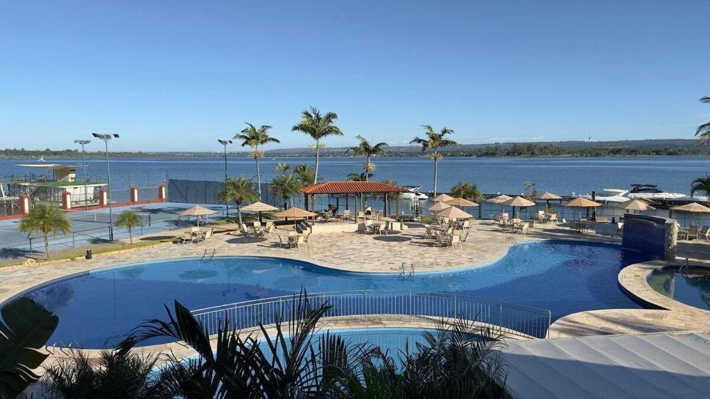 a resort with a large pool and a beach at Flat beira lago no centro de BSB in Brasilia